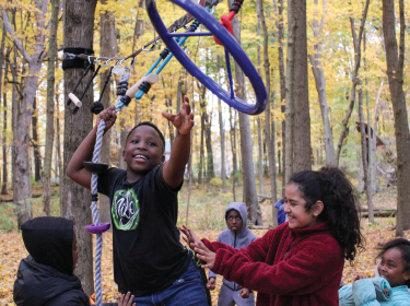 boy walking through ropes course
